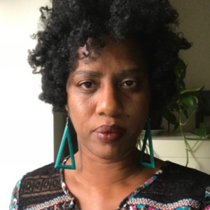 Photo of a woman wearing green earrings.