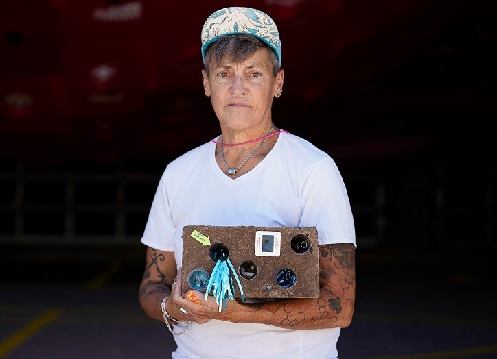 This is an image of an older adult participant holding their artwork.