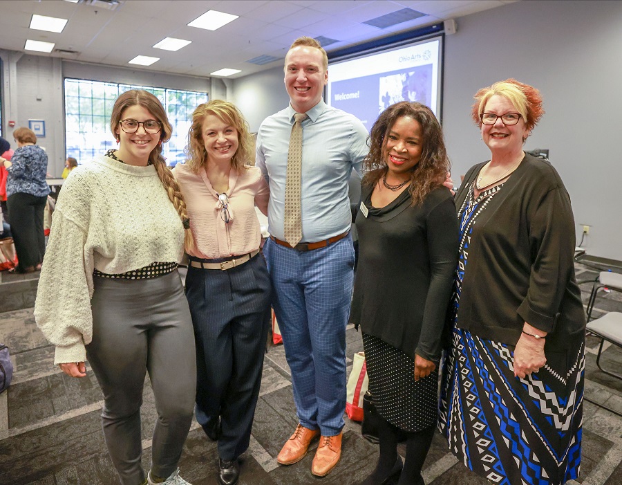 Group photo of 5 people who are standing together and smiling.